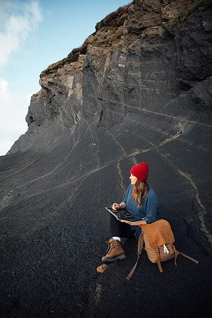 Woman writes in her journal at the Pembrokeshire coast