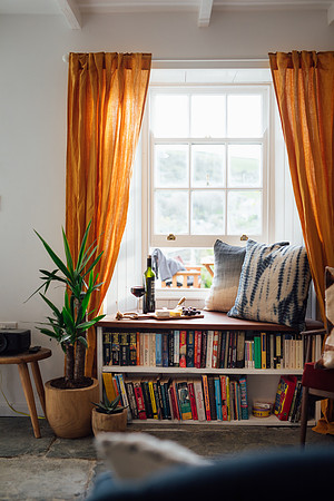 The bookshelf below the window at Beacon Cottage in Cornwall
