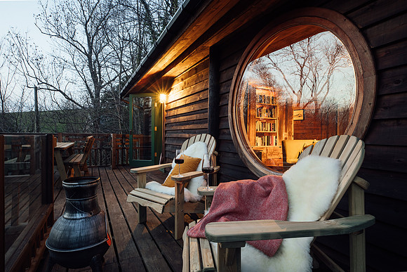 Evening time seating space with sheepskin rugs at Foragers Cabin