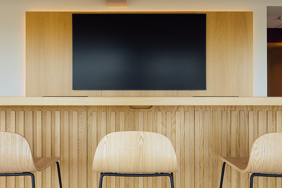 Wooden Stools facing a large LED screen