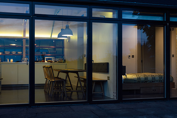 Looking through the windows at night into a smartly furnished holiday let
