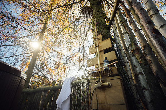 Water falls from the outdoor shower, illuminated by the winter sun