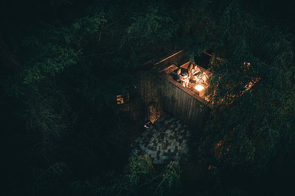 Drone image of couple enjoying the roof top terrace at Pomeroy Treehouse
