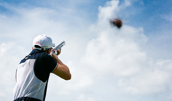 Clay pigeon shooter fires and hits his target