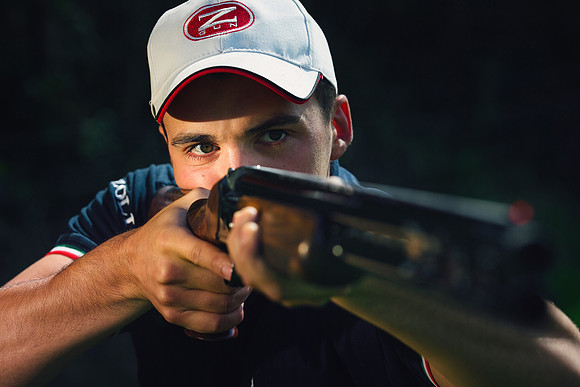 Clay pigeon shooter looking down the barrel of gun