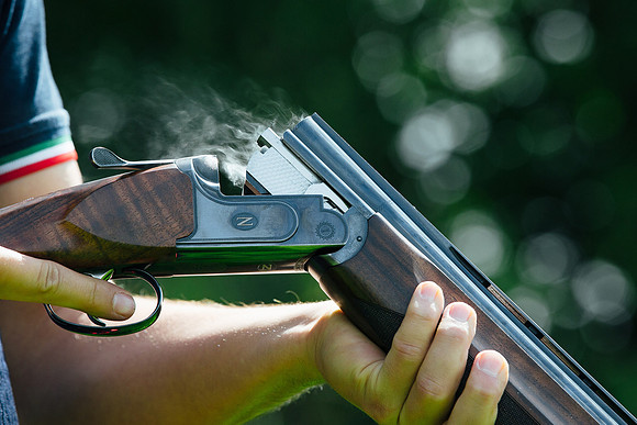 Smoke pours out of a recently fired shotgun