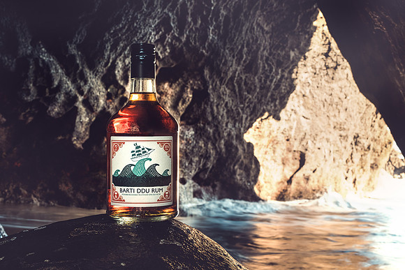 Barti Ddu Rum Bottle placed on a rock in a cave