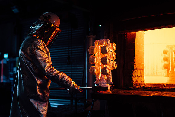 Foundry worker takes a mould out of a kiln