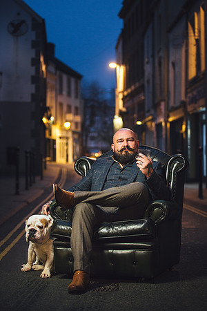 Man and his dog sitting in the street on Carmarthen highstreet