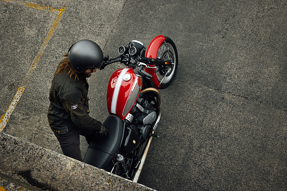 Looking down on a BSA Goldstar Motorcycle as a classically dress rider mounts