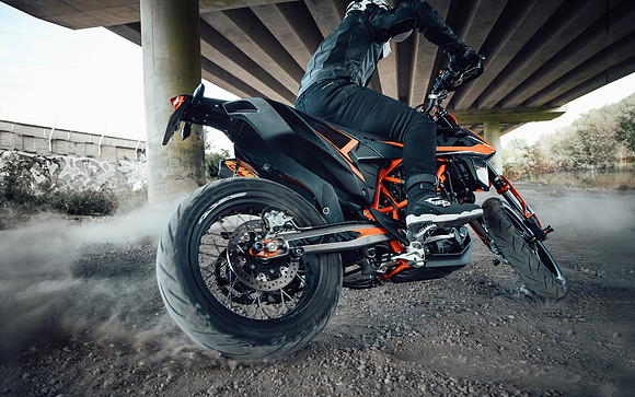 Stunt rider pulls a rear brake skid on a KTM 690 SM