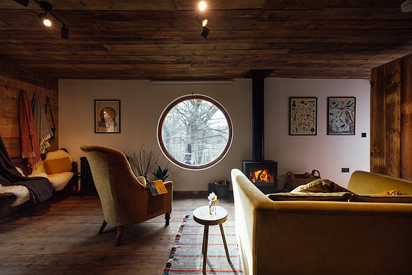 The indoor living space with circular window at Foragers Cabin