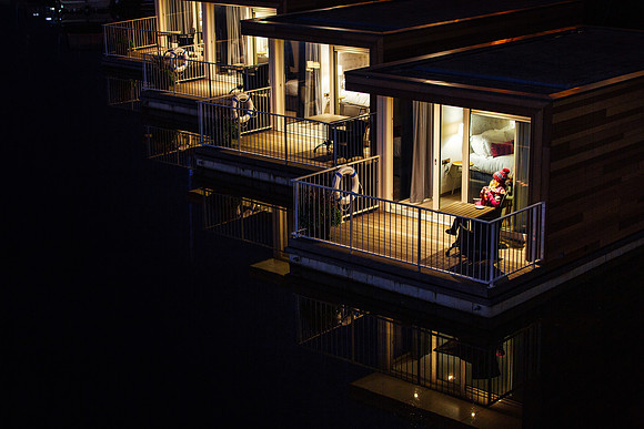 A girl cosies up in her jumper and hat with a hot chocolate on the floatel platform