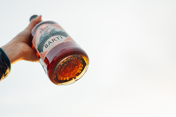 Barti rum bottle held up to the sky