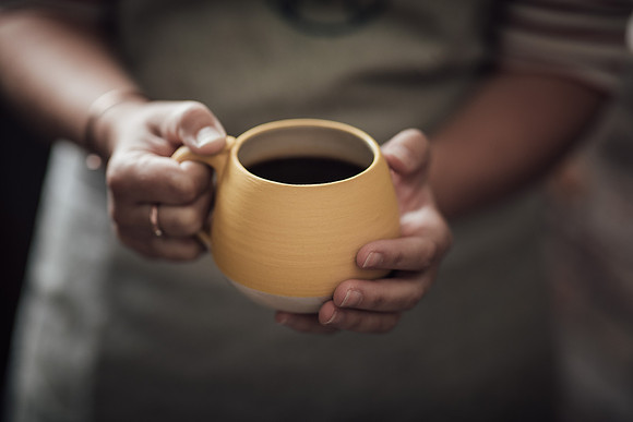 A mug made my Mena ceramics is held in hands