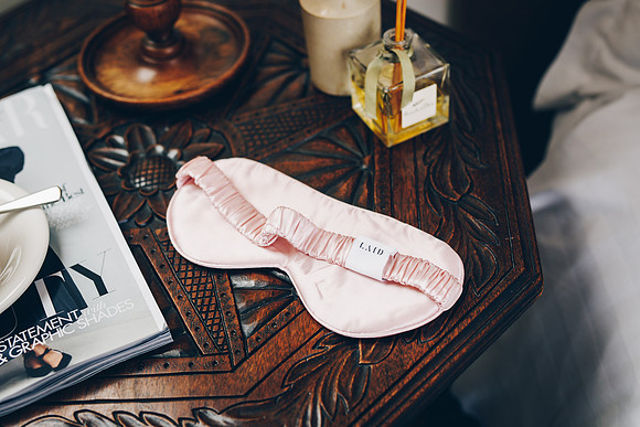 LAID Silk eye mask in pink on bedside table