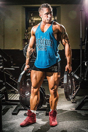 Bodybuilder carries weights in the gym
