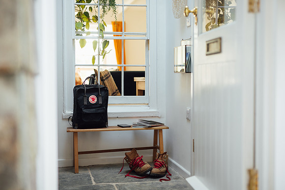 A black fjallraven backpack and Danner walking boots casually placed for airbnb photography